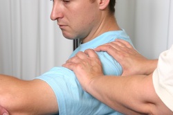 Treating man with shoulder problem using Bowen